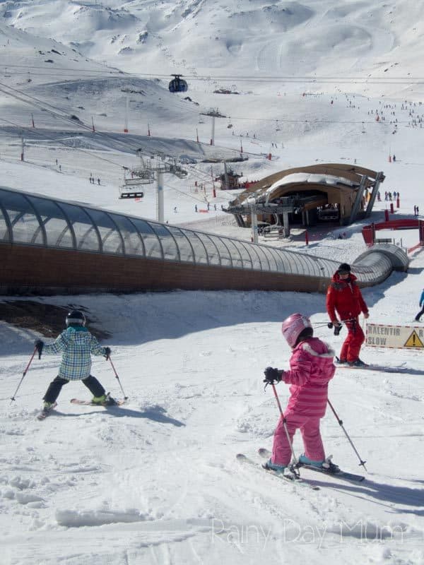 kids making their way down the slope snow plough to their ski instructor
